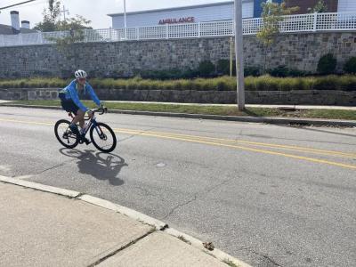 A rider passes Tobey Hospital. 