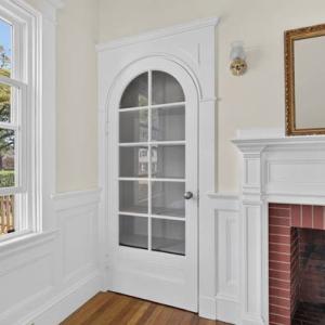 Original arched glass-paned door beside the fireplace in Unit 1, 370 Maple Street, New Bedford