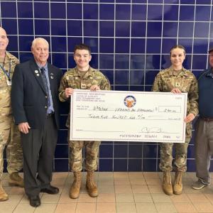 Col. Matt Stanton and JRTOC cadets Aaron Legg and Emily Morais accept a donation toward the town's Veterans Day Parade. Photo source: Nora Bicki